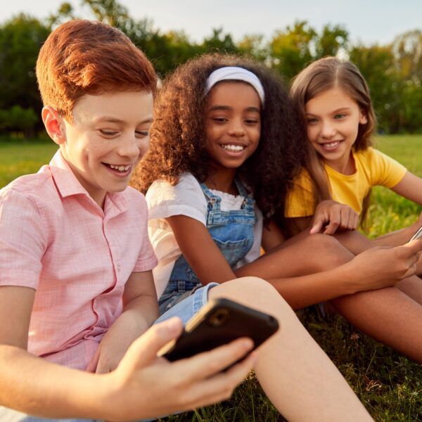 Diverse kids using smartphone together