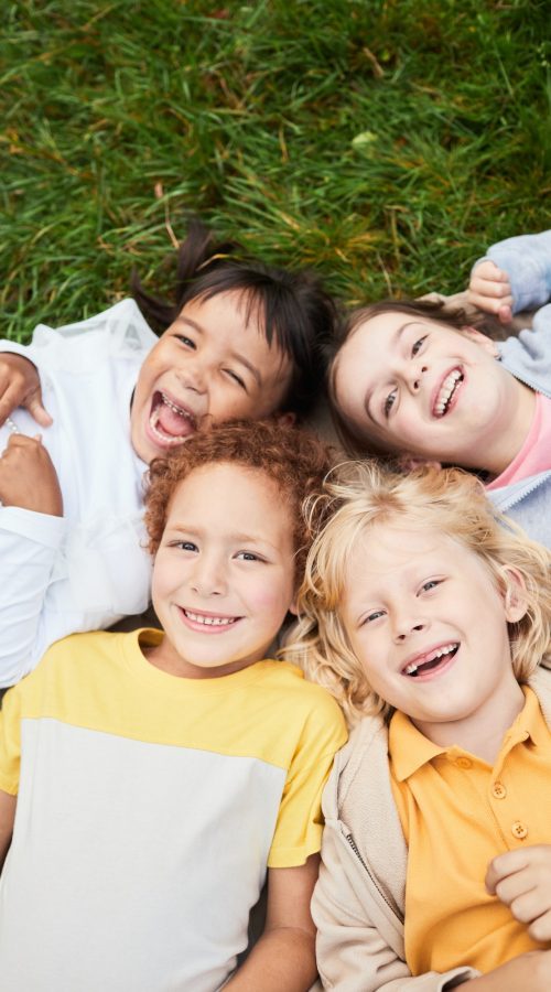 Smiling Children Lying on Grass