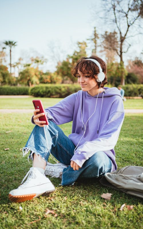 adolescenți Teenager listening to music in the park